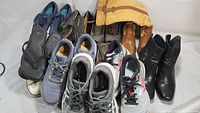 Overall view of multiple shoes including boots, sneakers, sandals, and moccasins.