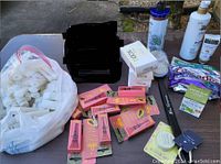 Overview of lot showing black shower brush, boxed soaps labelled Ivory and Cedar Musk, multiple lip balms, and many small white bottles