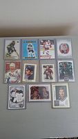 Full view of 11 assorted NHL hockey cards laid out, including a Wayne Gretzky rookie card, a card of Ilya Samsonov, and others in protective sleeves.