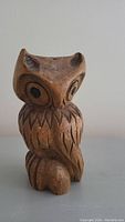 Front view of the handcrafted wooden owl showing facial details and feathers