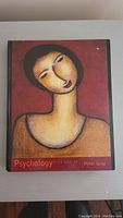 Front cover of the hardcover psychology book with an abstract portrait artwork, title, author and edition information.