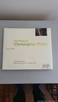 Front cover of the hardcover book The Prints of Christopher Pratt 1958-1991 showing title and author details with a small photo of Christopher Pratt.
