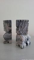 Side view of one bookend showing the Tiki Aztec warrior design with polished grey and white onyx stone.