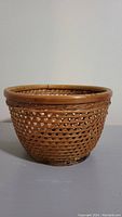 Front view of small round wicker basket showing open weave wicker pattern and solid rim.