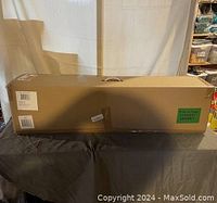 Boxed 6-foot Christmas tree in original packaging placed on table indoors.