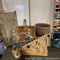 Photo showing metal folding laundry basket with fabric lining, natural wicker baskets, decorative metal wire basket and macrame hanging wall decor