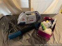 Photo showing Bissell SpotLifter cleaner, umbrella, and tin with assorted items in the lot.