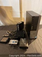 Overall shot showing Dell Optiplex 3020 desktop tower, two digital cameras, cassette player, digital scale, wristwatch, and numeric keypad.