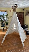 Large adjustable canvas teepee tipi standing in a room, showing full height and pole construction.