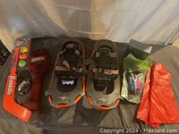 Full view of lot items including LL Bean snowshoes, inflatables, shin guards, mini hockey stick set, mini golf iron, and golf trade items