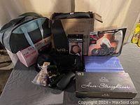 Shows all items in the lot including various boxed and packaged personal care products, hosiery, and carrying bag