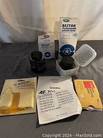 Photo showing Beston Automatic Zoom Lens with box, additional Beston lens in smaller box, Sigma instruction paper, and Kodacolor film box.