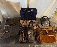 Photo of five assorted purses and handbags on a surface showing varying sizes, colors, and brands.