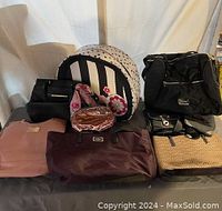 Full lot overview showing seven assorted purses and handbags of various colors and styles.