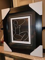 Overall view of professionally framed fine art print by Henri Matisse with protective white corner covers on frame