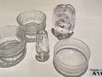 Top view of the set showing three textured clear glass bowls, small vase, and Bergdala Swedish troll figurine in clear glass.