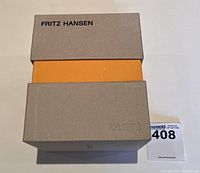 Closed gray cardboard box with Fritz Hansen logo, showing outer packaging of the vase set