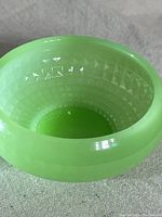 Close-up of the interior showing textured diamond pattern inside the pale green jadeite bowl.