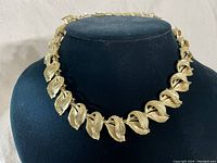 Full view of the gold-tone leaf choker necklace displayed on black bust.