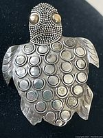 Front view of vintage sterling silver sea turtle brooch showing detailed shell and eyes.