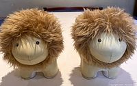 Front view of the pair of lion figures with fluffy manes and smiling faces