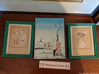 Three framed artworks including two child-themed prints with green wooden frames and a central wood or MDF mounted Kay Rasmus Neilsen Art Nouveau illustration.