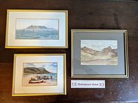 Three small framed watercolour prints on table with six inch ruler for scale.