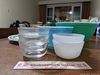Photo showing two large Pyrex mixing bowls (green and blue) and four small Pyrex-style glass dessert bowls (clear and white) with ruler for scale
