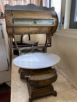 Full view of antique Dayton scale showing the scale dial, company name engraving, and white glass tray.