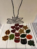 All 17 beaded coasters arranged on a striped surface under a wall decoration.