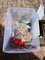 Plastic bin with cork stoppers, red bottle corker, metal funnel with white residue, and white dipping wax container