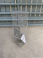 Front side view of the metal wire critter trap showing the spring-loaded metal door and wire mesh cage structure.
