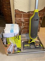 Shark floor sweep vacuum with box of mop pads placed on a tray showing product packaging and pads.