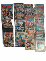 Top-down view of 22 assorted comic books arranged in 3 columns. Titles and cover art visible including superheros, Care Bears, Archie characters.