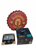Photo of the Manchester United bottle cap wall decor with the Razer Kraken headphones box stacked beside it showing both items in the lot