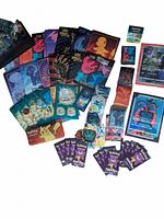 Wide view showing jumbo Japanese Pokémon V-star cards, 'Evolving' player guides, dice, markers, stickers, cards, and card sleeves spread out.