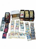 Image showing multiple deck boxes filled with Pokemon cards including energy cards and trainers, plus several stacks of loose cards.