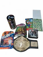 Lot overview showing all items included: sealed Tyco RC car, action figures, sticker sheets, timeline game, and championship belt.