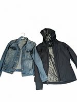 Two women's jackets laid flat on a white background: a Levi's medium denim jacket and a size medium black Dry Frame windbreaker with hood.
