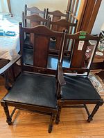 Front view showing two chairs in front of four others, one armchair at left, five side chairs behind