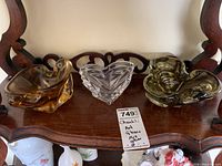 Three art glass bowls together on wooden surface showing amber Chantili bowl, clear bowl, and yellow-green bowl.