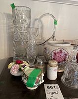 Overview of crystal vases, Royal Doulton floral china, broken Coalport creamer, salt and pepper shakers, and crystal bell.