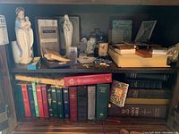 Shelf with religious books, crosses, porcelain figurines, and additional religious items