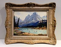 Full view of framed mountain and lake landscape oil painting.