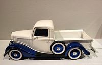 Side view of the vintage Solido diecast truck model showing white cab and truck bed with blue front fenders and matching wheels. Spare tire mounted on side.
