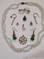 Full view of all jewelry pieces including necklace, earrings, pendants, and brooch.
