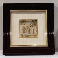 Front view of the framed sterling silver artwork depicting a village street scene with buildings and trees.