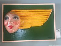 Front view of sculpture mounted on blue wall