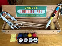 Overview of wooden box interior with wickets, mallet and Jaques sign on lid