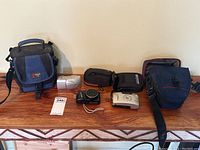 Overview of three cameras and four cases on wood surface